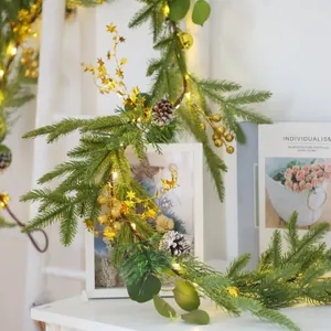 Christmas garland with warm LED lights, pine cones and gold stars for home holiday decor