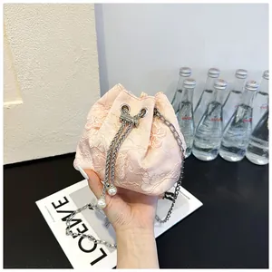 Détail du sac seau en dentelle rose avec broderie 3D, chaîne et breloques en perles