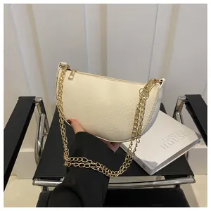 Detail der cremeweißen Leder Baguette Tasche mit Lychee Textur und goldener Kette