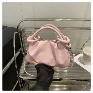 Détail du sac à main plissé rose avec poignée ronde et bandoulière en cuir souple