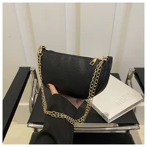Nahaufnahme der schwarzen Leder-Tasche mit Litschistruktur und goldener Metallkette