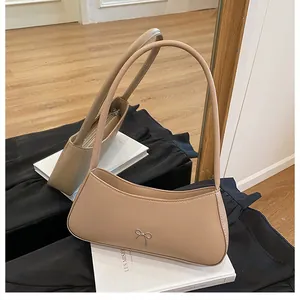Detailansicht der hellbraunen Baguette-Tasche mit silberner Schleife und Reißverschluss