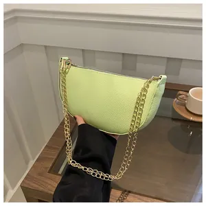 Nahaufnahme der hellgrünen Mondsichel-Tasche aus strukturiertem Leder mit goldener Kette