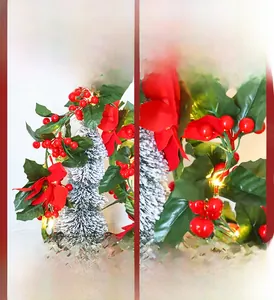 Close-up of artificial poinsettia flower and red berry LED string lights for Christmas decor