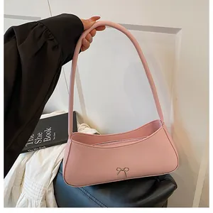 Rosafarbene Hobo-Tasche mit Metallschleife und Reißverschluss, getragen von einem Modell