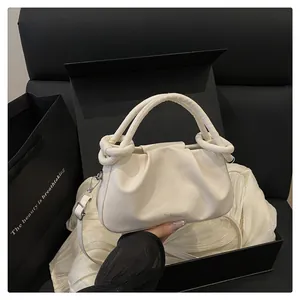 Détail du sac nuage plissé crème avec poignées circulaires et ferrures en métal argent