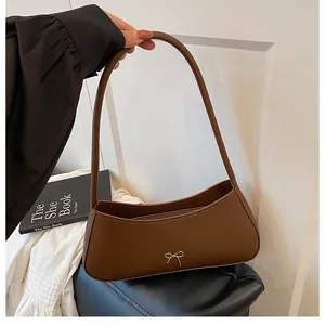 Nahaufnahme der silbernen Metallschleife an einer braunen matten Leder-Schultertasche