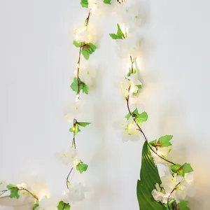 Artificial cherry blossom vine string lights with warm LED glow for home wall decoration