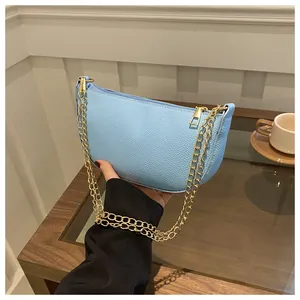 Nahaufnahme der hellblauen Crescent-Bag mit Litschistruktur und goldener Kette