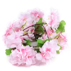 Artificial cherry blossom LED string light with green leaves and battery box on white background