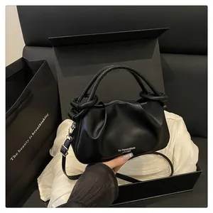 Détail du sac nuage noir plissé avec poignée anneau sur soie et boîte cadeau