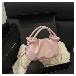 Détail du sac nuage froncé rose clair avec poignée nouée dans une boîte cadeau de luxe