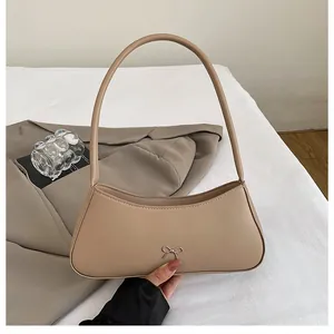 Detailansicht der beigen Schleifen-Handtasche mit elegantem Metall-Detail und PU-Leder