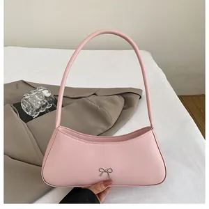 Nahaufnahme einer rosa Leder-Schultertasche mit silberner Schleife aus Metall