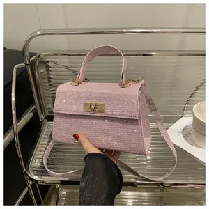 Detailed view of pink sequin handbag featuring a gold metallic lock and detachable strap