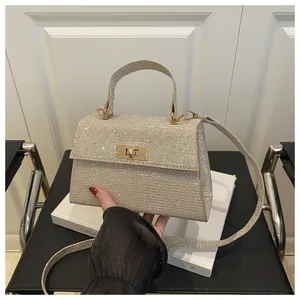 Macro view of champagne gold sequined handbag with gold twist lock and metallic handle