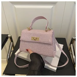 Detailed close-up of pink sequined square crossbody bag with gold metallic turn-lock