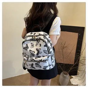 Detail of printed butterfly pattern and golden zippers on women's casual backpack