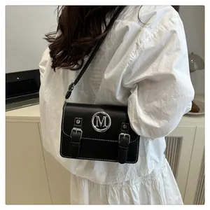 Black leather crossbody bag with metal M logo and double buckle design for women style.