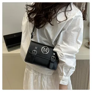 Stylish black leather crossbody shoulder bag with metal M logo and double buckle closure.