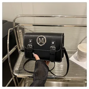 Black leather satchel bag with contrast stitching and metal M logo detail for women.