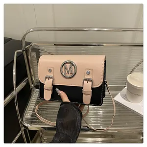 Detailed view of the stylish two-tone colorblock mini crossbody bag with metal M accent.