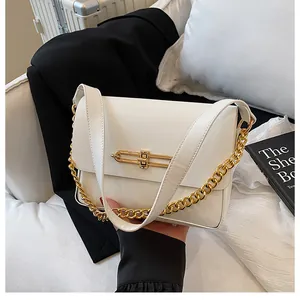 Detail of white leather shoulder bag with chic geometric gold buckle and chain strap