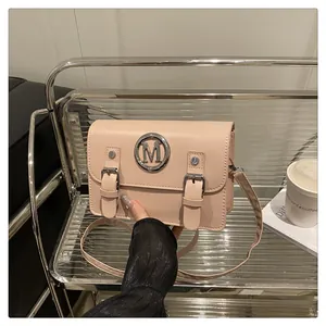 Pink PU leather satchel crossbody bag featuring metal M logo buckle, stylish shoulder bag.
