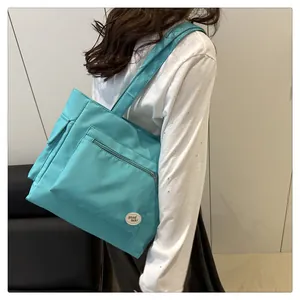 Detail view of lake blue canvas tote bag showing zipper pocket and good luck label