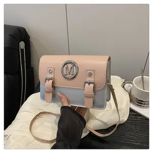 Color block small crossbody bag with metal M logo detail, stylish pink and silver womens handbag.