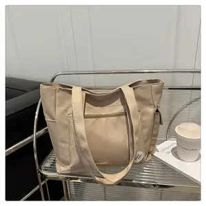 Detail view of beige canvas tote bag with good luck patch on a stylish metal cart
