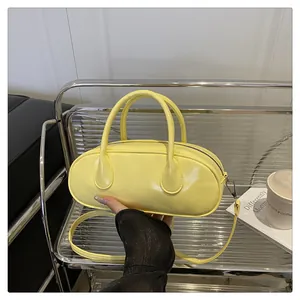 Moderne gelbe PU-Leder Baguette-Tasche, handgehalten in einem stilvollen Umfeld