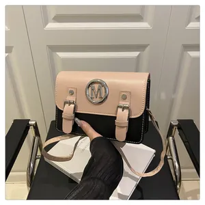Stylish two-tone crossbody satchel bag with metallic M logo and dual buckle straps.