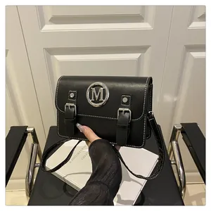 Black leather crossbody bag with metal M logo and double buckle design for women.