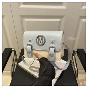 Two-tone crossbody bag with metal M logo and buckle straps, stylish PU leather satchel purse.