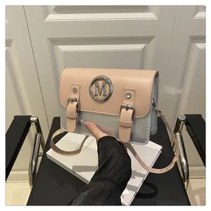 Chic pink and silver colorblock satchel bag with retro double buckle and metal ring detail.