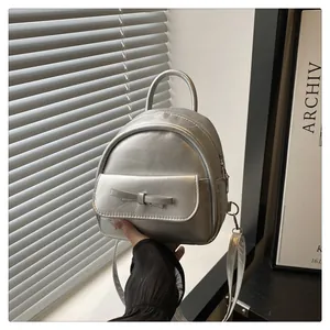 Detail of silver mini backpack showing metallic PU texture and decorative front bow