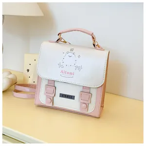 Dettaglio dello zaino in ecopelle rosa e bianco con gatto e fibbie in metallo dorato