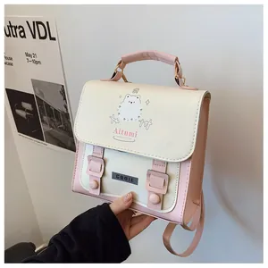 Dettaglio di una borsa a tracolla carina beige e rosa con motivo a cane e fibbie magnetiche