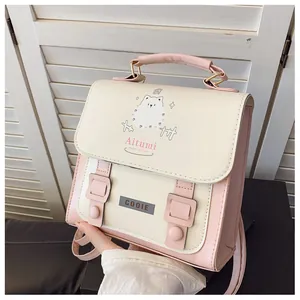 Dettaglio zaino in pelle rosa e crema con illustrazione di cucciolo e finiture in metallo