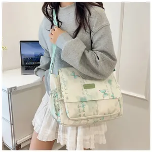 Detail view of butterfly print canvas messenger bag with adjustable green strap
