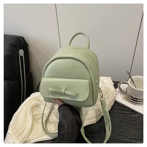 Detail view of the light green mini leather backpack with a smooth matte texture and zipper