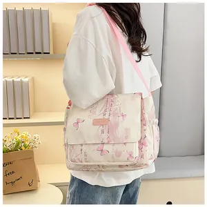 Detail of butterfly and calligraphy prints on a cream canvas shoulder bag with pink strap