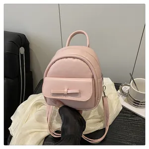 Close-up of pink mini backpack with bow detail and premium matte PU leather texture