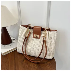 Détail du sac tissé avec un fermoir rotatif en métal doré et des finitions en cuir