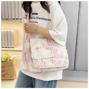 Detail of canvas messenger bag featuring pink butterfly print and calligraphy texture