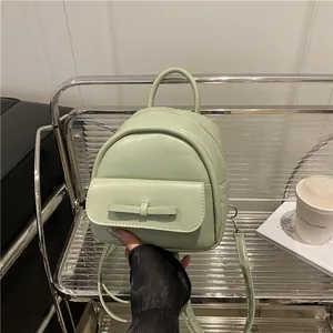 Mini light green PU leather backpack with bow detail on a stylish lifestyle setting
