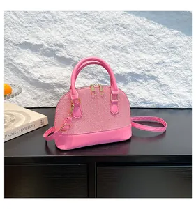 Detail of pink dome handbag showing woven texture, gold-tone hardware and dual zippers