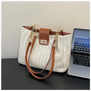 Détail du sac cabas beige tissé main avec bordure en cuir et fermoir en métal doré