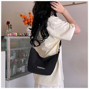 Detail of black nylon crossbody bag with fashion print and adjustable strap on model